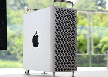 Apple Mac Pro, recently discontinued, sits on a white desk with a window showing green forest in the background