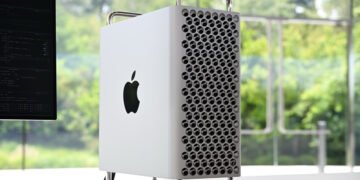 Apple Mac Pro, recently discontinued, sits on a white desk with a window showing green forest in the background