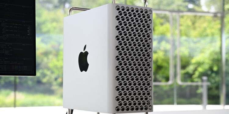 Apple Mac Pro, recently discontinued, sits on a white desk with a window showing green forest in the background